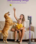 Woman and child playing with a dog beside a Heavy Duty Cordless Stick Vacuum, 60KPa Beast Suction, 650W Motor, Self Standing.