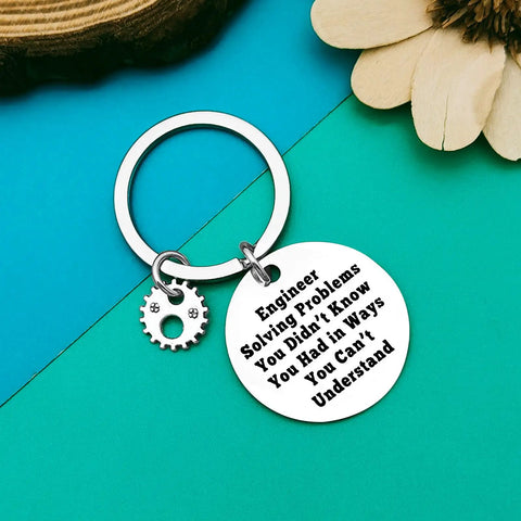 Engineering Student Keychain Gift For Engineers And Builders Mechanical Theme Construction Nerds Graduation Teacher Appreciation Perfect Gift For Science Math Computer Civil Mechanical Engineering Fans with engraved message and gear charm on blue background.