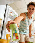 No Sweat Deep Chamber Ice Molds With Spin Top Silicone Lid crafting ice cubes in a man's hand inside a refrigerator.