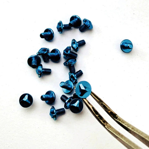 Twelve Piece Blue And Purple Titanium Triangle Screw Kit For Microtech Utx 85 And Ultratech Otf Knife Rigs on a light surface.