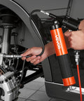 Pro Grade Heavy Duty 6000 PSI Grease Gun Kit With Pistol Grip in use, lubricating automotive components with a flexible hose.