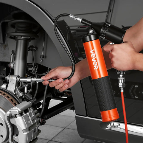 Pro Grade Heavy Duty 6000 PSI Grease Gun Kit With Pistol Grip in use, lubricating automotive components with a flexible hose.