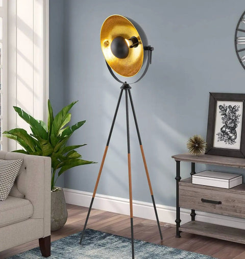 Lit Modern Tripod Floor Lamp in Black Finish with Gold Foil Circular Shade and Leather Accented Legs, 58 Inch Tall in living room