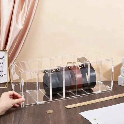 Top Shelf Slick Acrylic Belt Organizer With Removable Dust Cover Seven Compartment Clear Drawer Storage For Ties Belts Bow Tie Purse Socks, with three rolled belts visible.