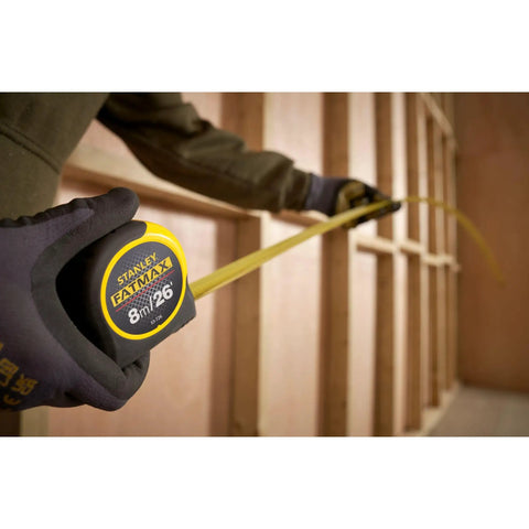 Person using Fatmax Tape Measure With Blade Armor And Dual Scale 8m Length, Mylar Coated Blade Delivers 10x Abrasion Resistance