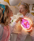 Two children in costumes holding Anime Luna Neon Sign LED Dimmable Moon Cat Night Light For Bedroom Wall Decor Lit Pink Kawaii Neon Light