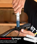 Person using Magura Hydraulic Brake Bleed Kit for disc brakes with mineral oil fluid 120ml and graduated syringe