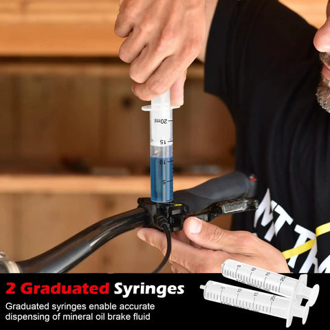 Person using Magura Hydraulic Brake Bleed Kit for disc brakes with mineral oil fluid 120ml and graduated syringe