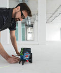 Pro Level 12V Green Beam Cross Line Laser With 100 Foot Reach And Smart Visimax Tech being used for alignment on a construction floor.