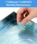 Hand holding blue AC Drain Pan Tablet over metal pan, labeled for 12,000 BTU use, AC Drain Pan Tablets 120 Count for Condensate Systems