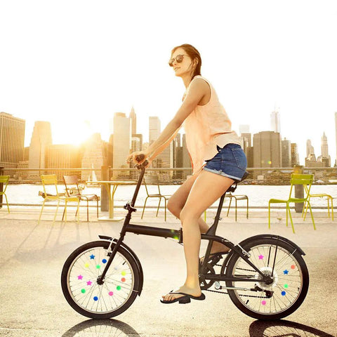 Woman riding bike with Colorful Bike Spoke Beads Set 72 Piece Plastic Clip On Wheel Decorations For Kids Assorted Colors And Shapes