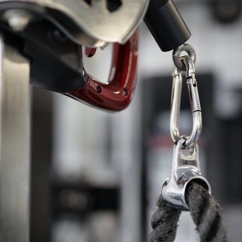 Close-up of a 3.5-inch silver metal carabiner clipped to rope, showing a spring-loaded gate.