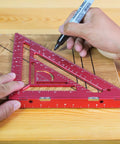 Person using a 7.5-Inch Magnetic Rafter Square With Jig Block Multi-Angle Measuring Tool in red for precise carpentry on wood.