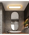 Slick Modern Wall Sconces With Smooth Remote Dimming For Real Cozy Living Rooms And Bedrooms Solid Rust Proof Metal Crafted With Crisp Acrylic Panels Delivering A Chill Glare Free Glow Everywhere Indoors in bathroom setting with mirror and stone walls.