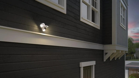 3 Light LED Outdoor Flood Lights With Dusk To Dawn Sensor Adjustable Brightness mounted on dark house exterior at dusk