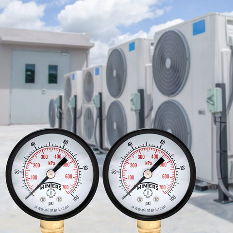 Front close-up of two Winters 2-inch pressure gauges with brass internals, black steel cases, psi/kPa, 1/4 in. NPT.