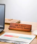 Two Pack Blank Wood Name Plates For Desk In Walnut Finish displayed on wooden desk near laptop, customizable for offices.