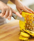 Gel Finger Cots Set 20 Piece Silicone Finger Protectors in use while chopping pineapple on a wooden board.