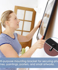 Picture frame turn-button fasteners set; metal hardware with screws; front view of a woman mounting a frame