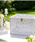 Slick White Silhouette Wedding Card Box With Lock And Slot, Dope Floral Hollow Envelope Holder on a reception table.