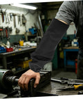 Legit Flame Resistant Welding Sleeves And Built Different Cotton Arm Guards Offering Heavy Duty Heat Protection For Serious Shop Work And Mechanic Hustles with a hand resting on a metal workbench.