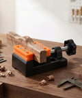 Compact Mini Bench Vise Featuring Smooth Parallel Jaw Clamping For Precision Watch Repair Sculpture Diy Carving And Home Shop Projects Built Different Heavy Duty holding a wooden piece on a workbench.