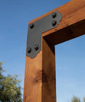 Mission Collection ZMAX Black Powder Coated L Strap For 6x6 Posts 12 Gauge Steel Outdoor Accents attached to wooden frame outdoors