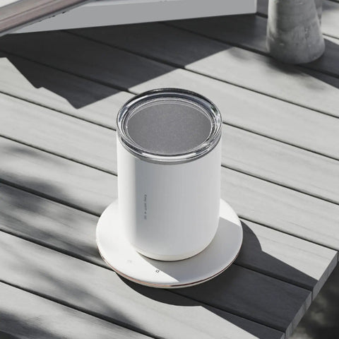 Slick 2 In 1 Self Stirring Heated Coffee Mug With Automatic Mixing And 3 Chill Proof Temp Modes For Coffee Milk Cocoa Protein Shakes 300 Ml Stainless Steel on a wooden table.