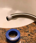 Pipe with Pro Grade PTFE Thread Seal Tape for Plumbers 1 Inch by 520 Inch next to a sink, showing leak-proof sealant use.