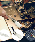 All In One Sewing Machine Cleaning Kit with tweezers and double-headed brush next to sewing machine components