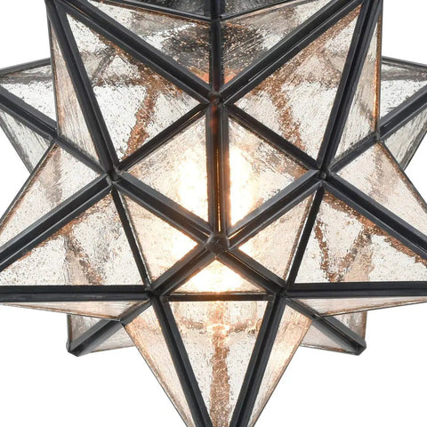 Close-up of Moravian Star Flush Mount Ceiling Light in black iron with seeded glass shade, illuminated and detailed view