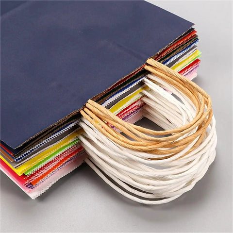 Stack of colorful handle Kraft paper bags with durable handles and reinforced bottoms. Portable grab and go option.