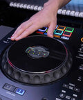 Hand using Four Deck All In One DJ System With A 10.1 Inch Touchscreen Built In Wi Fi SonicLink Wireless Tech Performance Pads And Beat FX