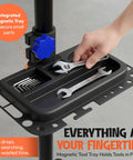 Hand placing wrench on magnetic tool tray of Bike Repair Stand With Workstand Mat And Detachable Wall Mount Clamp Ebike Floor Holder.