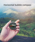Trail Ready High Precision Horizontal Bubble Compass Portable Circular Navigation Tool in hand with mountain view
