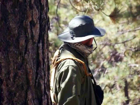 Person wearing a hat and Cotton Shemagh Keffiyeh Tactical Desert Scarf Neck Head Wrap With Tassel For Men And Women 41 By 43 Inches Tan