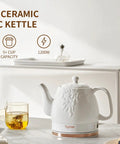 Electric Ceramic Tea Kettle With 1 Liter Capacity on a kitchen counter with teacup and lemon, modern white leaf finish, 360 swivel base.