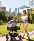 Woman using Super Lightweight Clip On Chair Parasol With Heavy Duty Universal Clamp UPF 50 Plus UV Protection on stroller in park.