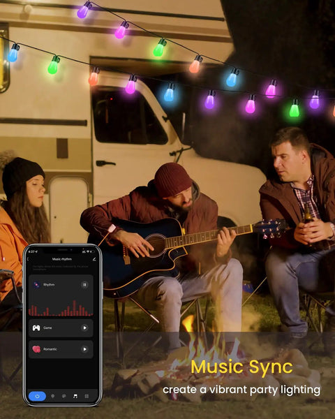 Smart RGB Outdoor String Lights 96ft With Independent Bulb Color Control, colorful bulbs above people sitting by a campfire.