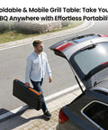 Person carrying folded Grill Table For 17 Inch And 22 Inch Griddles, Tailgate Ready Portable Grill Cart with Wheels by their car.