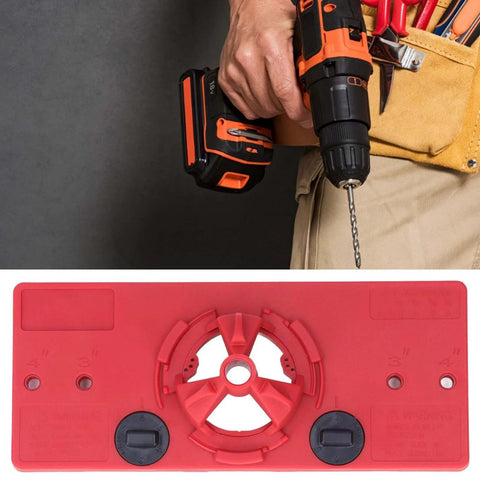 Red woodworking hinge drilling jig with 35mm hole saw, cordless drill in hand.