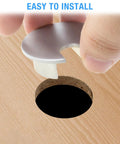 Set Of Two Bronze Desk Grommets Straight Up Sturdy Zinc Alloy Cable Management Covers being installed into desk hole.