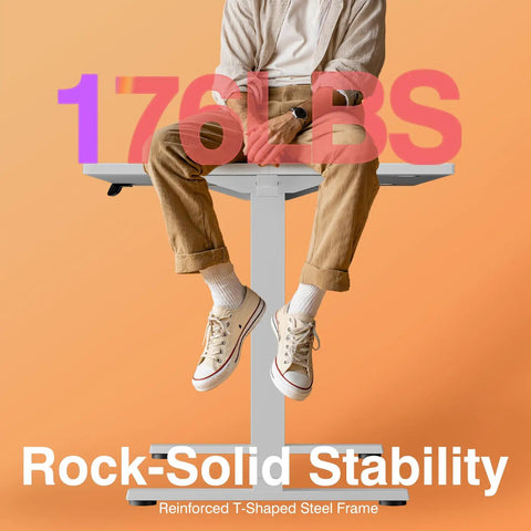Person sitting on Electric Standing Desk With 3 Memory Presets, 48x24 Inch Sit Stand Office Desk, showcasing stability under 176 lbs.
