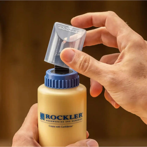 Handy Wood Glue Applicator Tips Featuring Durable Silicone Nozzles And Secure Plastic Collars For Super Smooth Box Joint Assembly Includes Protective Caps And Quick Cleanup Brushes For No Sweat Adhesive Control being placed on a glue bottle.