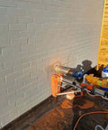 SALI wet diamond core drill system mounted on brick wall for masonry drilling; orange base, blue head, yellow motor.