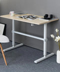 Built Different Crank Adjustable Height Standing Desk with sweet white maple top, 120 by 60 cm, suitable for office space.