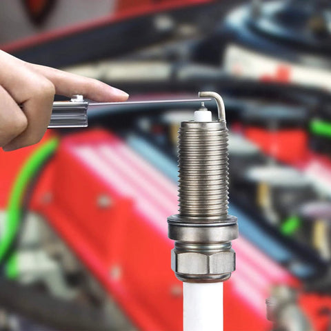 Close-up of steel feeler gauge set with dual metric/imperial blades measuring a gap on a threaded metal fitting