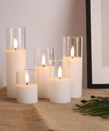 Clear Glass Flameless Candles With Remote Set Of 5 Slim Tall LED Pillar Candles on a table with beige cloth and artwork.