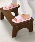Person using Wooden Toilet Stool For Kids And Adults, Anti Slip Bamboo Potty Training Step Stool, 7 Inch Rise, in bathroom