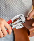 Heavy Duty Metal Hole Punch Kit With Chrome Vanadium Steel Punches used on brown leather material in a workshop setting.